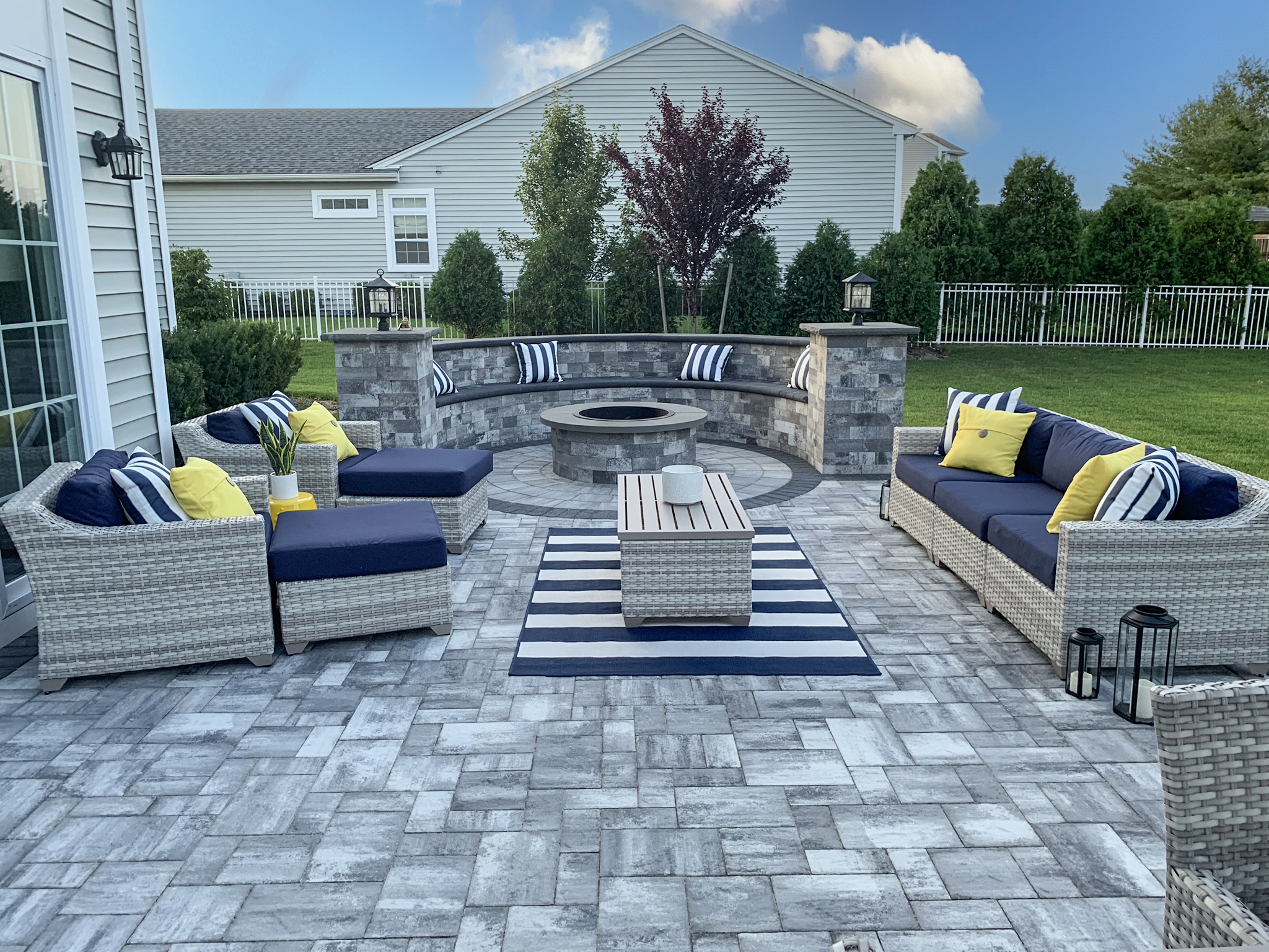 Cambridge paver patio with curved block seating wall and built-in fire pit — Long Island NY outdoor living contractor