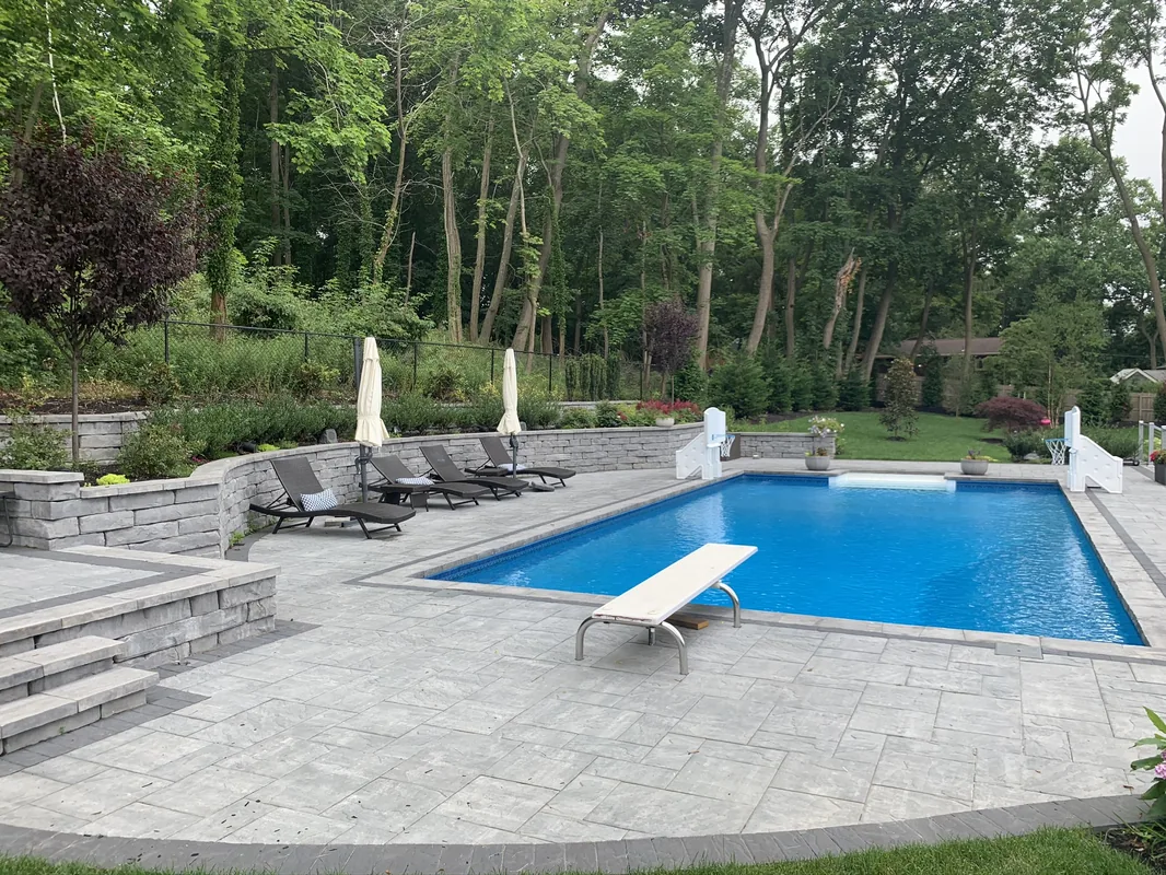 Vinyl pool with retaining wall and outdoor kitchen