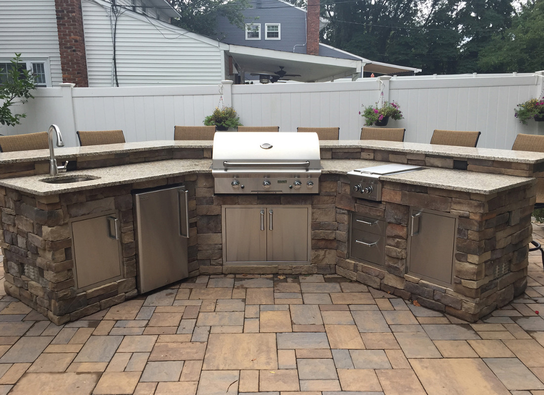 outdoor kitchen with sink, grill, and fridge