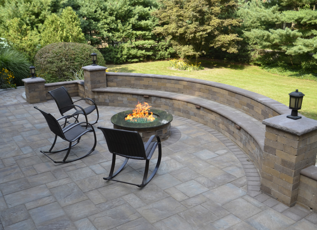 stone half moon seating area on patio with matching fire pit