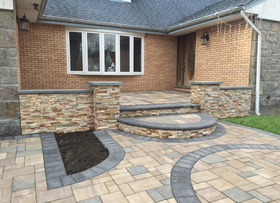 rectangular stone porch leading down to stone walkway and driveway