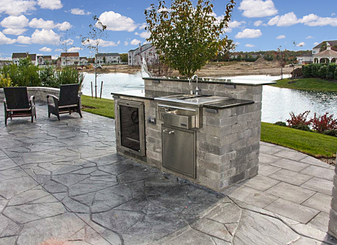 small outdoor kitchen with sink and refrigerator