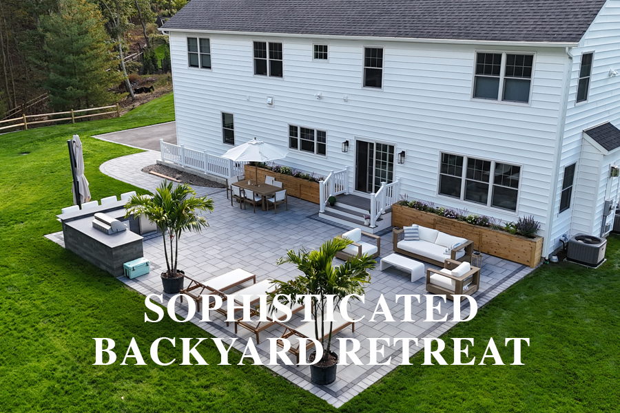 A spacious backyard patio with outdoor furniture, potted plants, umbrellas, and a grill area behind a large white house; text reads "Sophisticated Backyard Retreat.