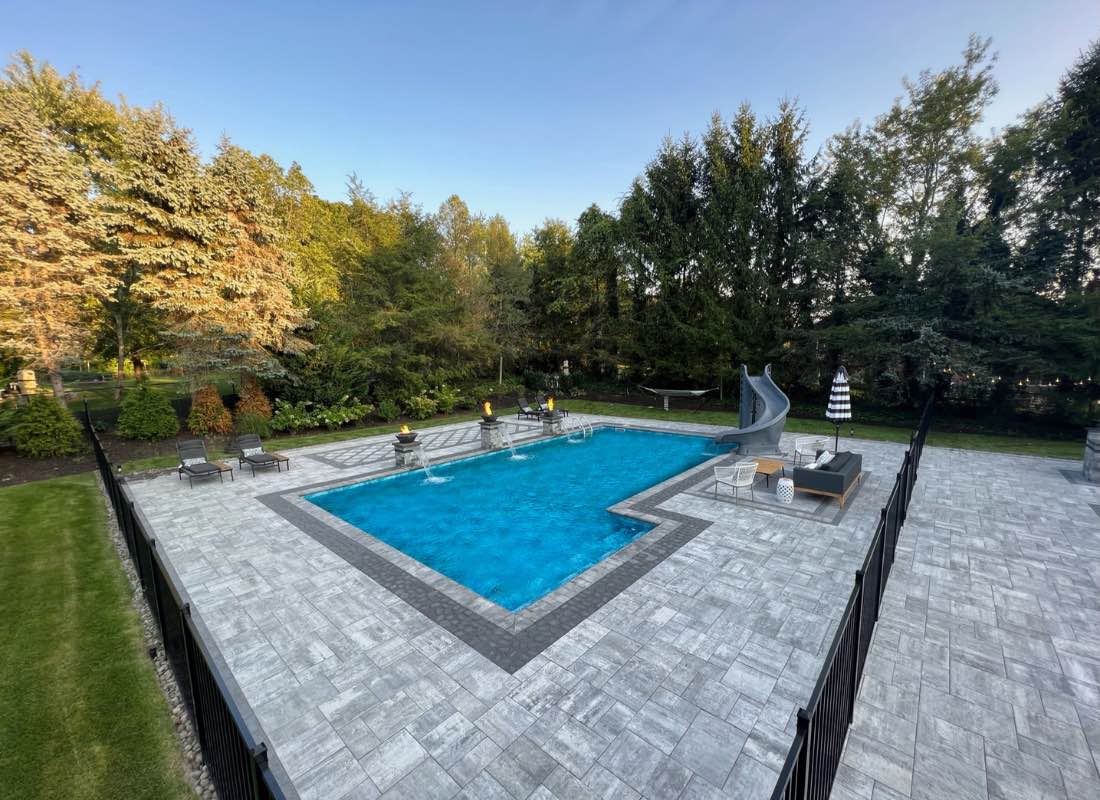 Concrete pool installation Northport NY — large pool with manicured landscaping by Flawless Masonry