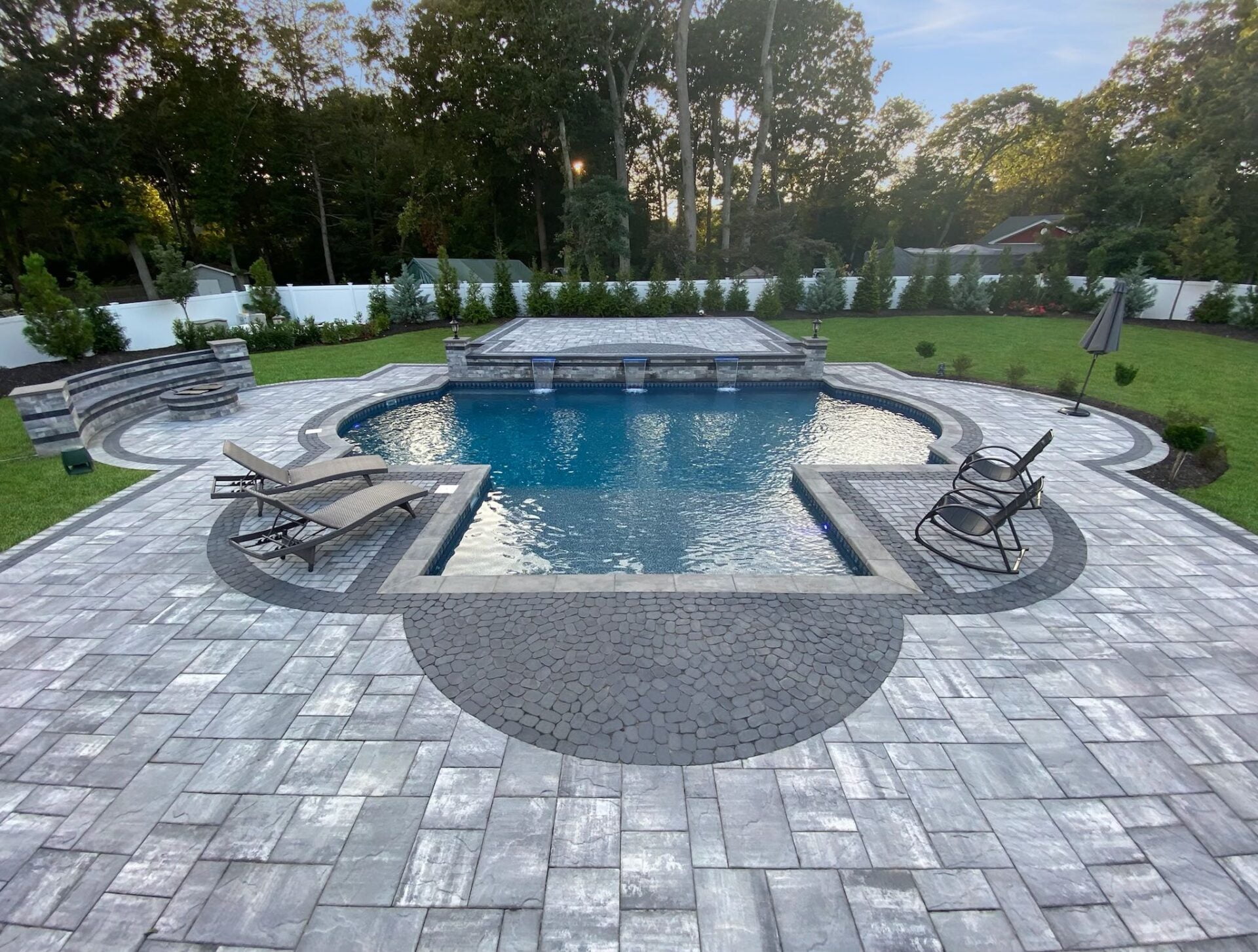 Pool installation Northport NY — custom in-ground pool with stone patio and outdoor living space by Flawless Masonry pool installer